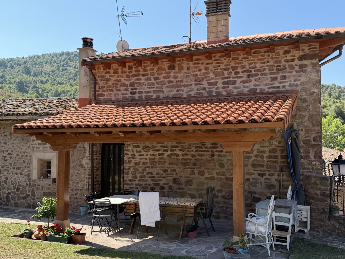 Porche de madera junto a vivienda de piedra, obra de Montajes Depedro
